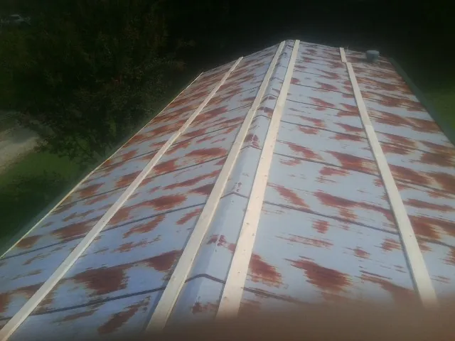 Rusted metal roof panels with new wood purlins before replacement — Storm Damage Roof Repair in Kendall by Roofing Brothers