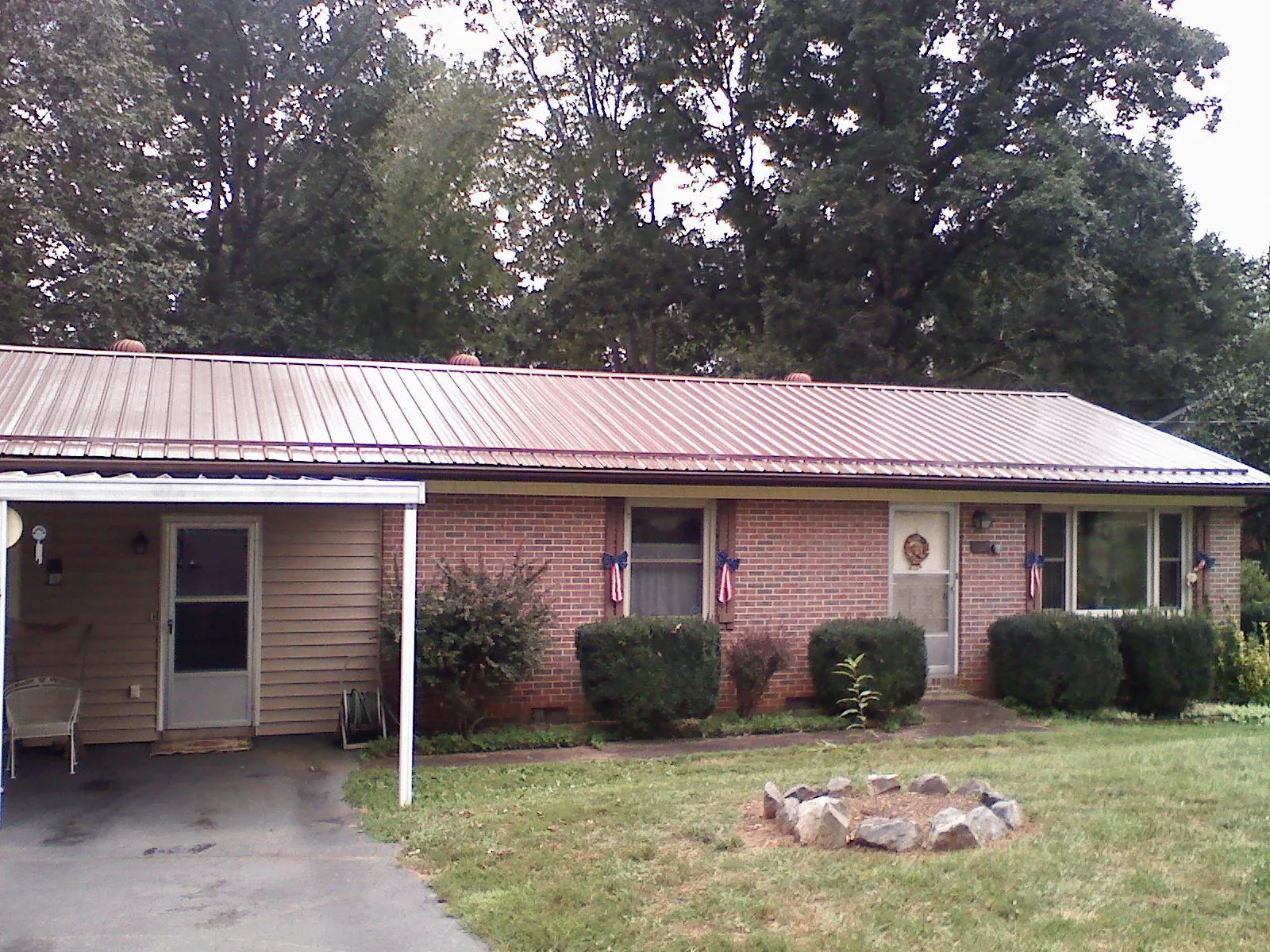 Bronze metal roof and carport on a brick ranch home — Roof Repair work by our crew in Kendall